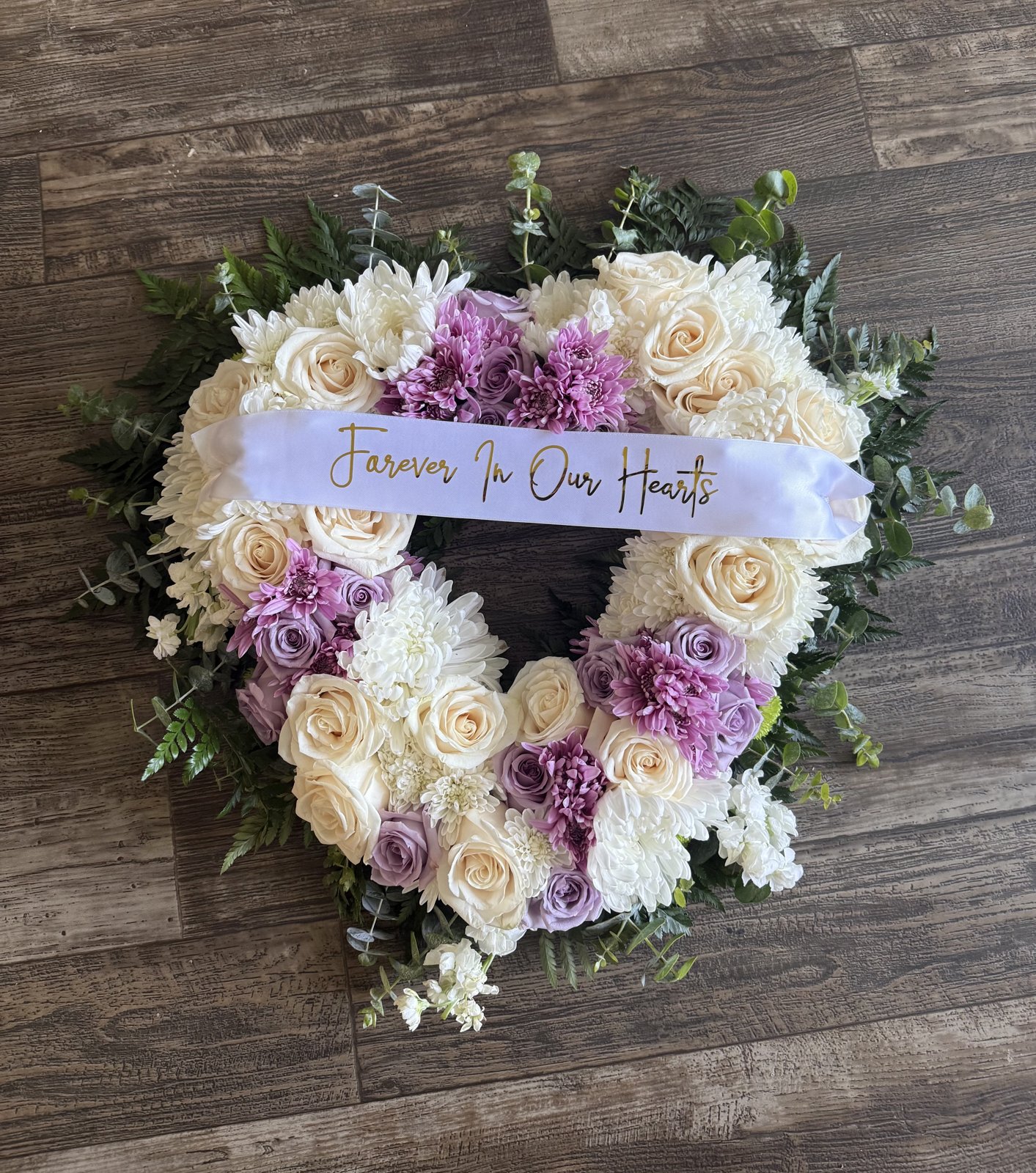 ‘Forever In Our Hearts’ heart-shaped sympathy wreath in ivory roses and lavender chrysanthemums by Zuri Blooms