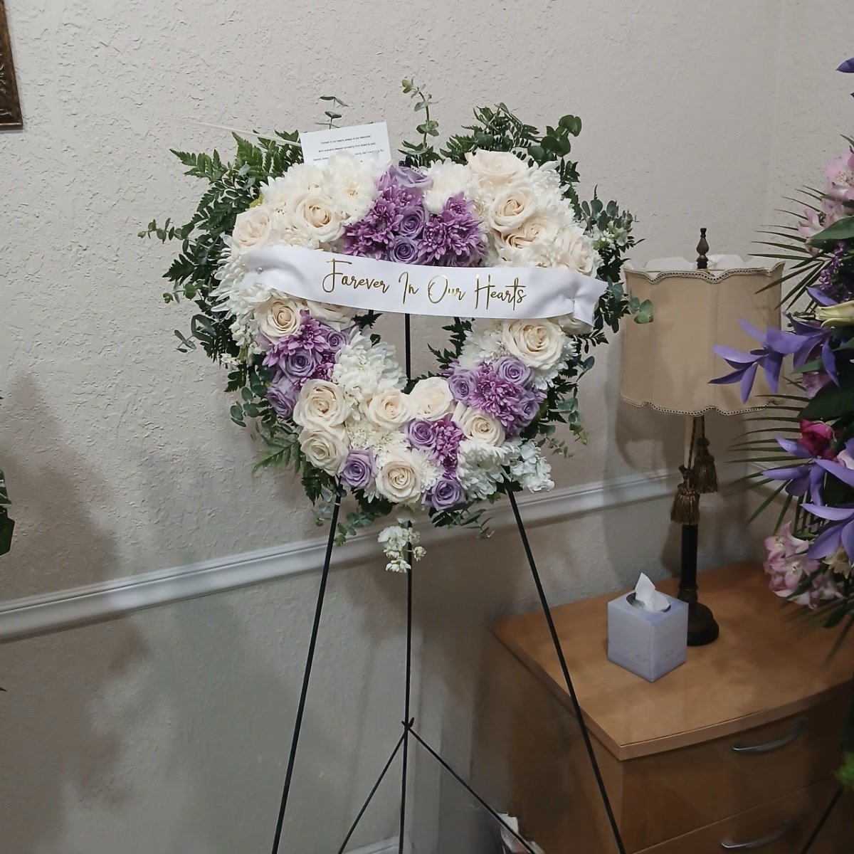Standing sympathy heart wreath on easel with ivory and lavender blooms, styled for a service in South Florida